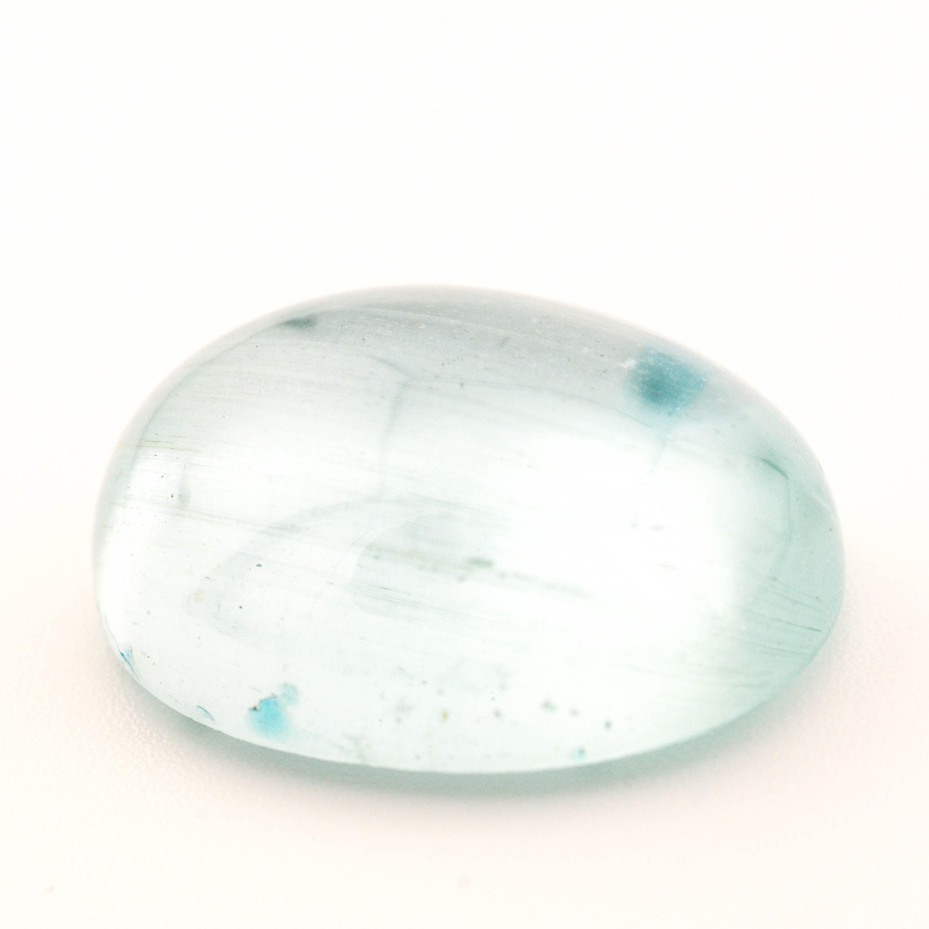 Clear gemstone with blue inclusions on a white background