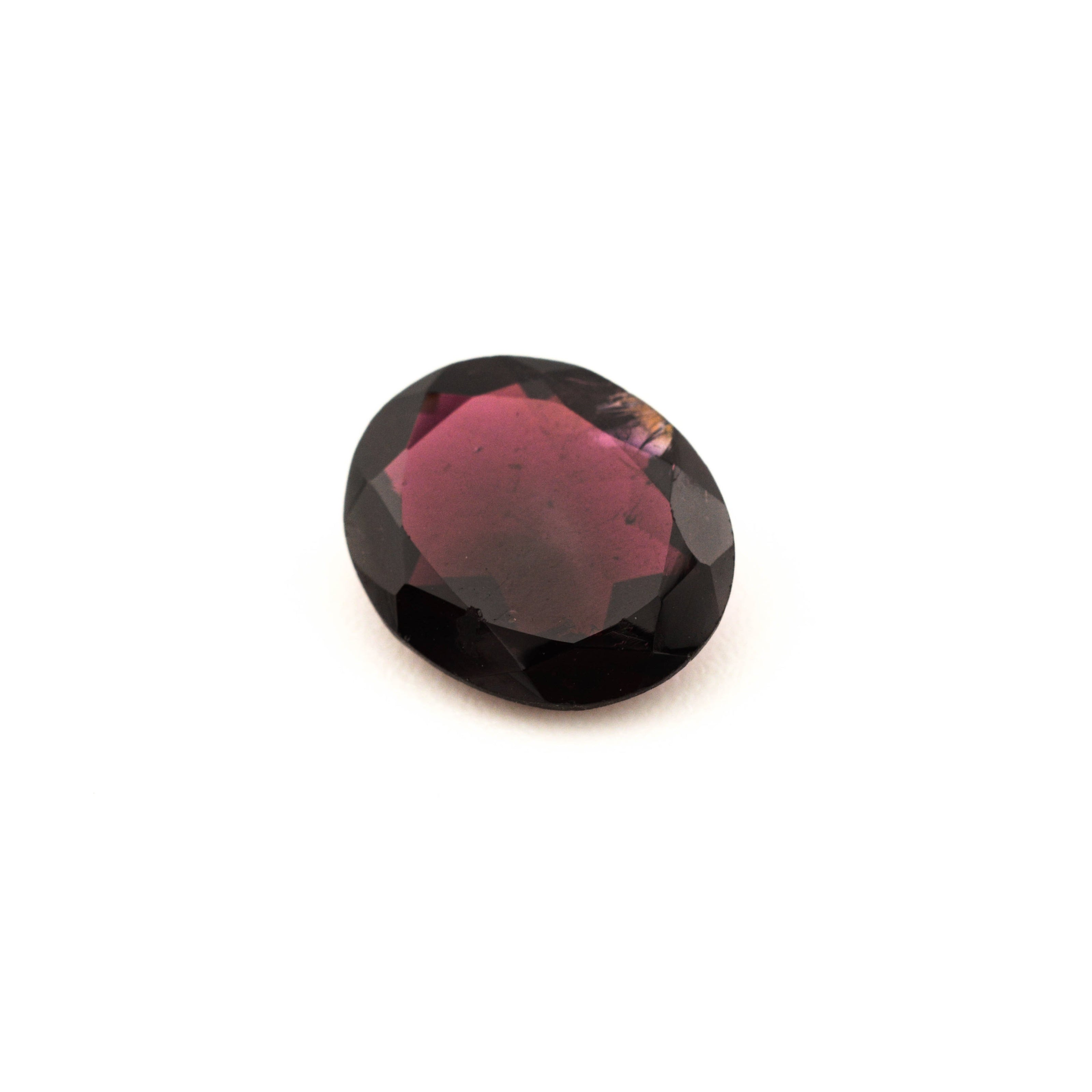 Round red gemstone on a white background