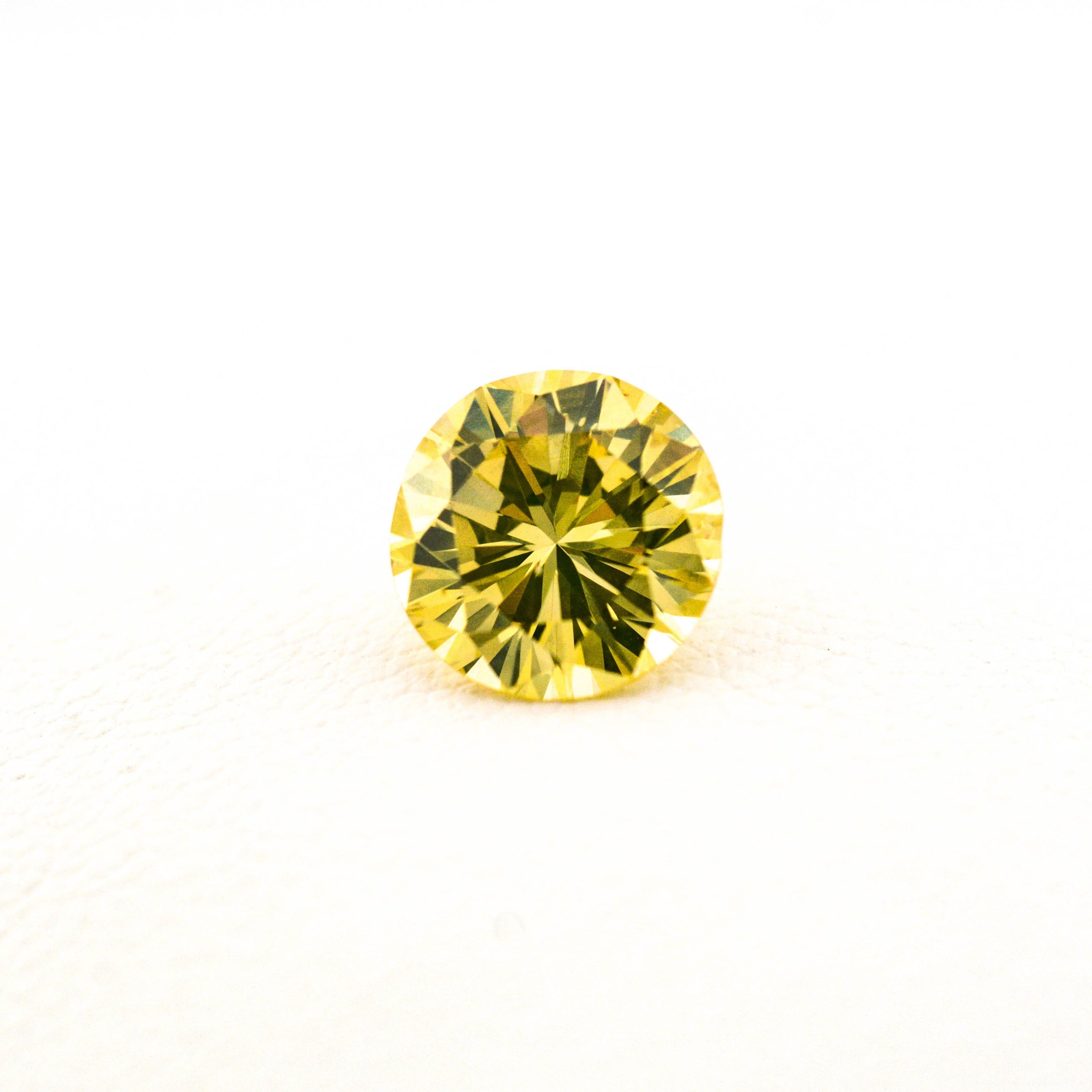 Round yellow gemstone on a white background